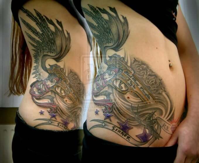 side stomach angel wing with gun and sinner banner tattoo design
