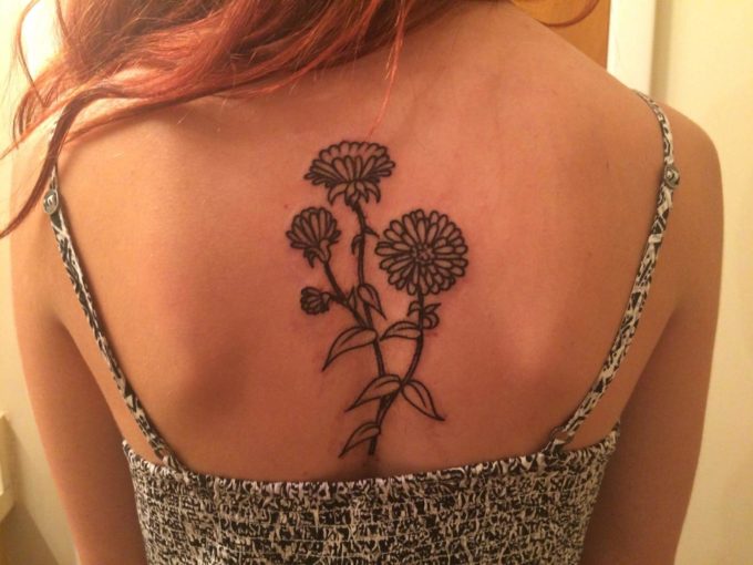 black and white aster flower tattoo on back