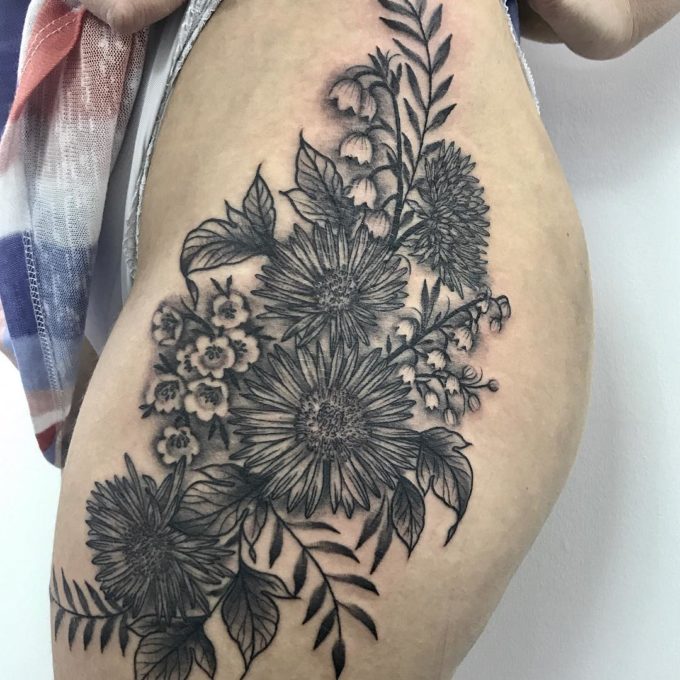black and white detailed floral tattoo on side thigh