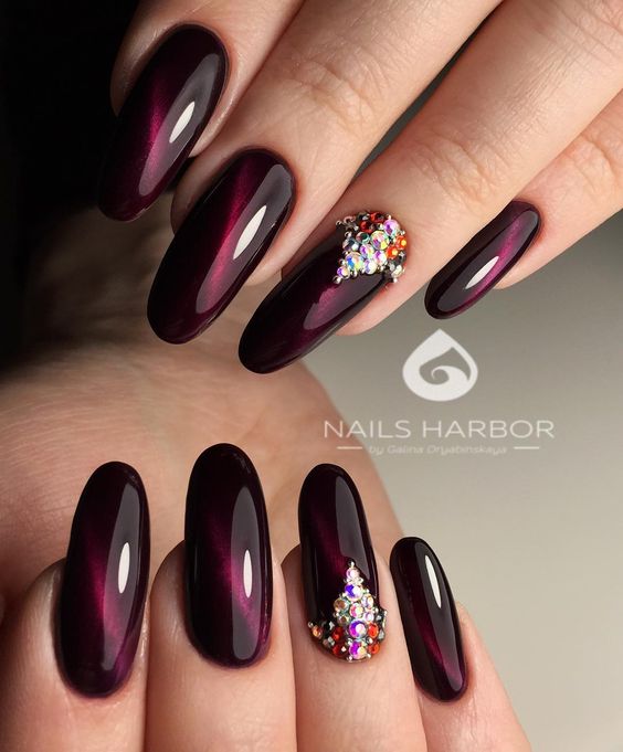 dark maroon nails with pearls on one finger