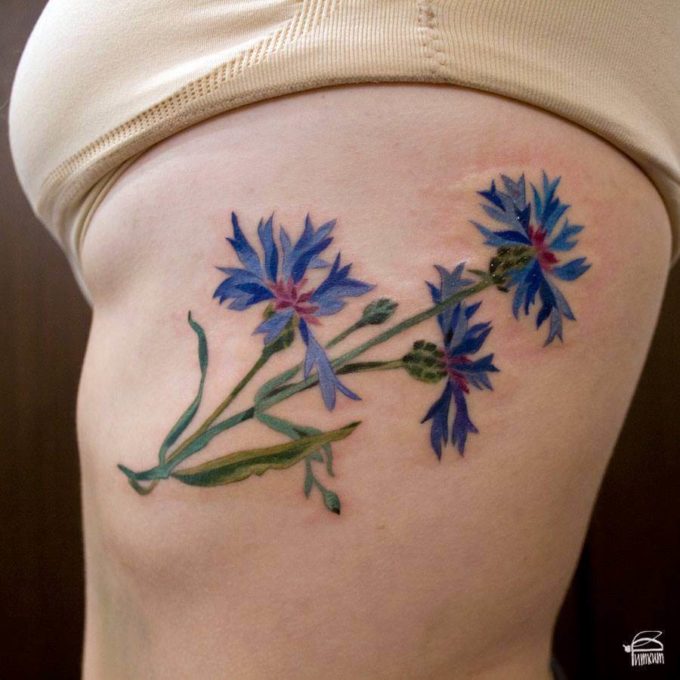 cornflower tattoo design on rib cage for females