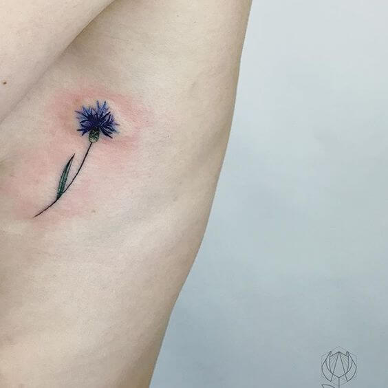 small cornflower tattoo design on ribs for men