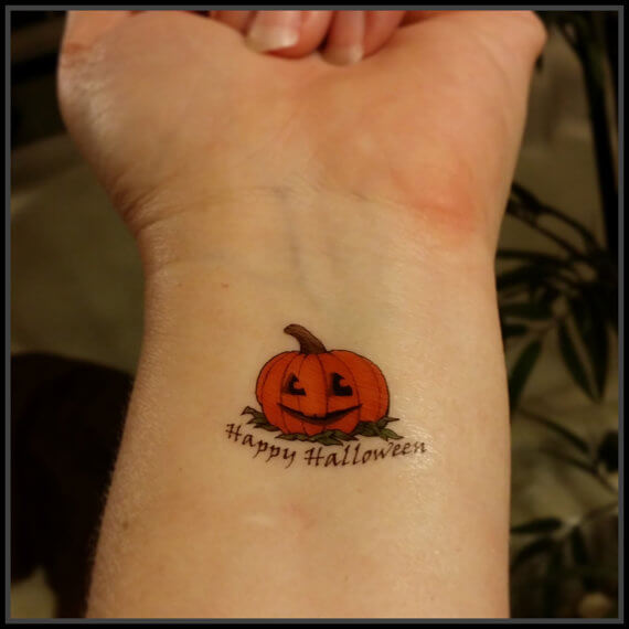 happy halloween pumpkin tattoo on wrist
