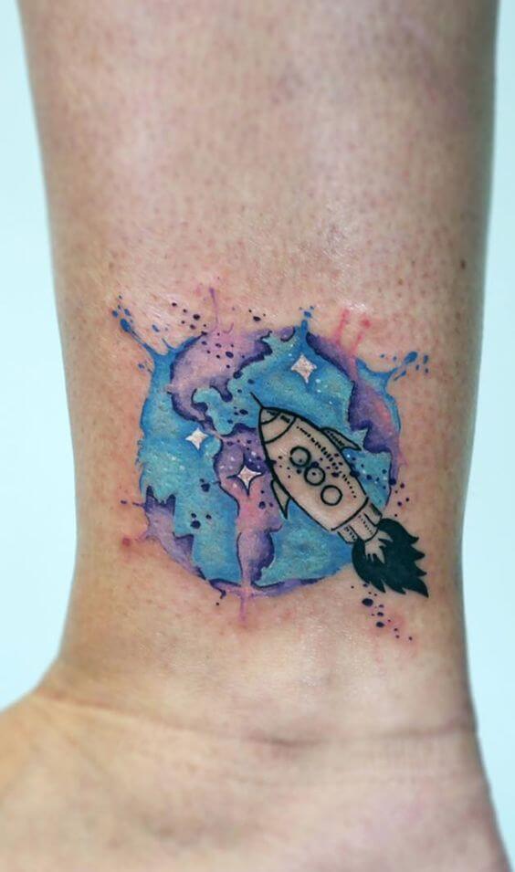 small rocket in space tattoo on wrist