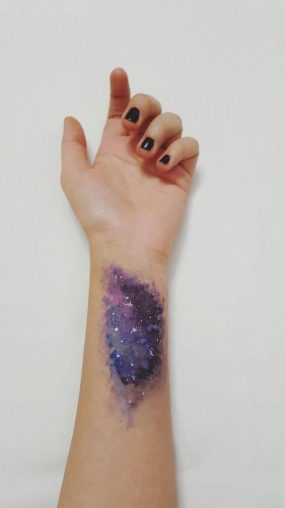 watercolor galaxy astronomy tattoo on wrist