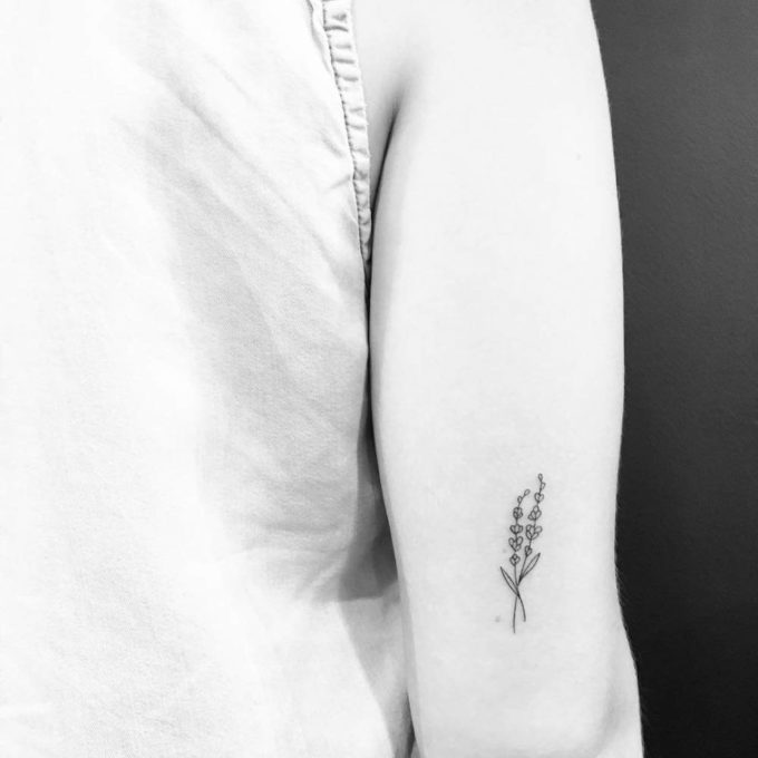 minimalist lavender sprig tattoo design on back arm
