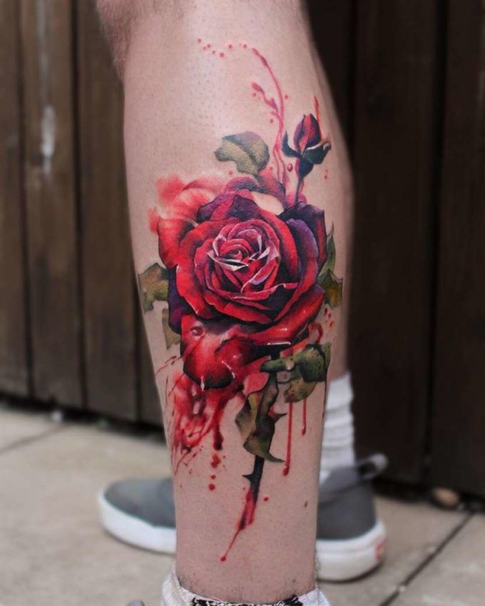 deep shades of red bleeding rose tattoo design on leg