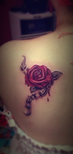 single bleeding rose with thorny vine tattoo design on back shoulder blade
