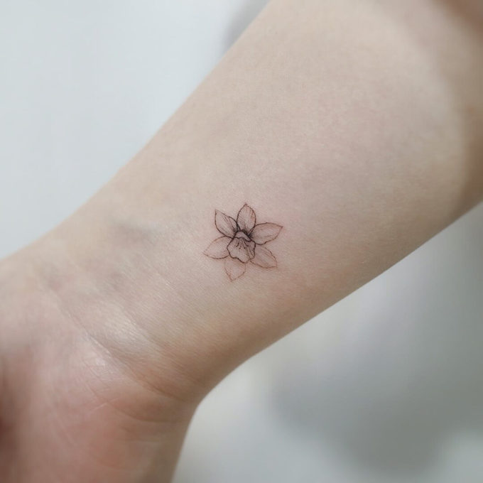 tiny december birth flower narcissus tattoo on wrist