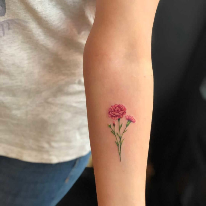 pink carnation January birth flowers with buds tattoos on forearm