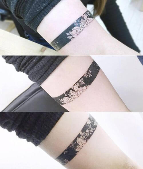 floral black band tattoo design idea on the arm for women