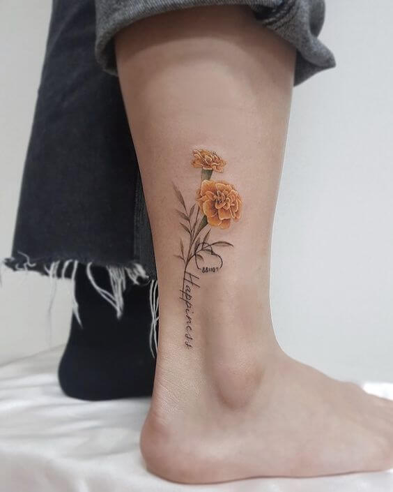 yellow carnation January birth flowers with happiness written tattoo design on ankle