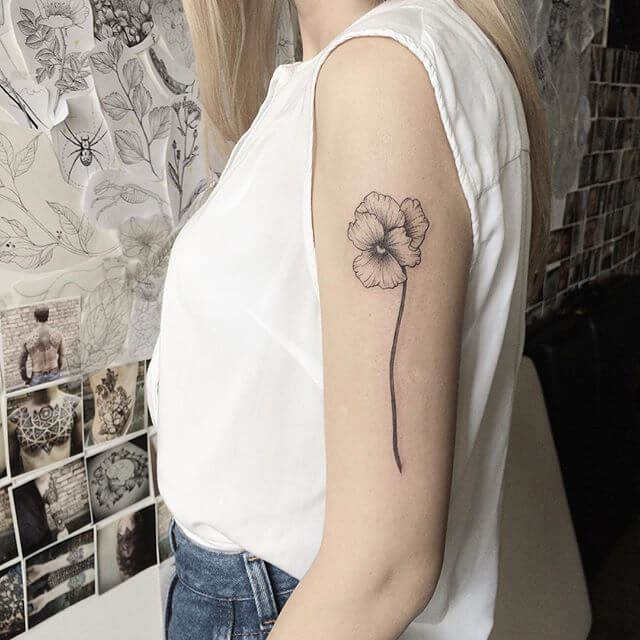 black and white viola flower bud tattoo design on upper arm
