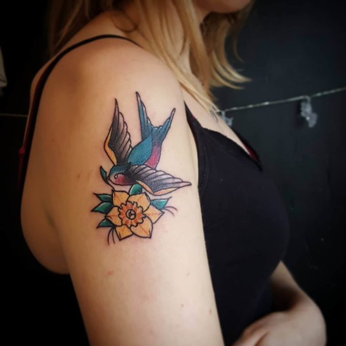 old school swallow with daffodil march birth flower tattoo design idea on shoulder for women 