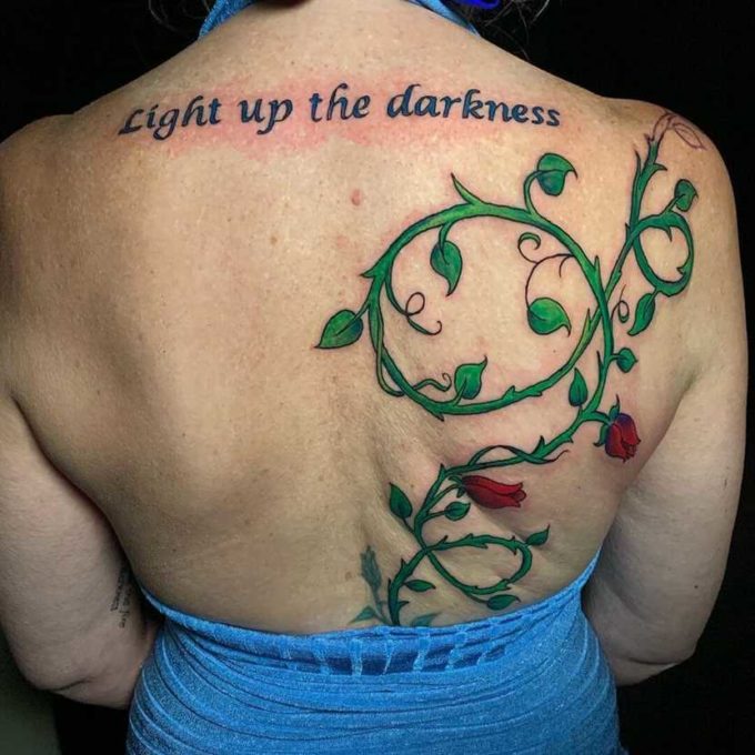 light up the darkness quote with rose vine tattoo design on back for females