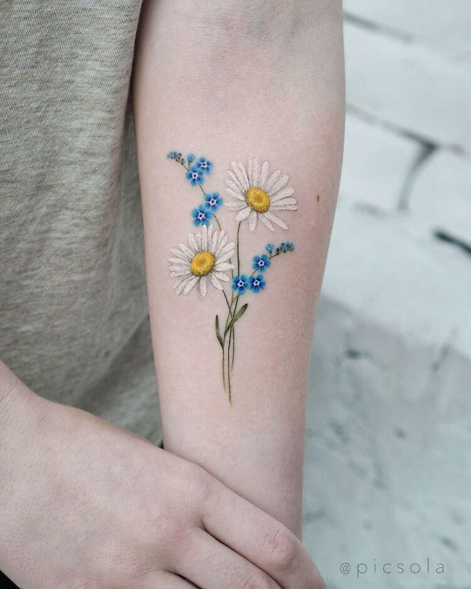 colorful daisy flowers april birth tattoo design idea on forearm for females