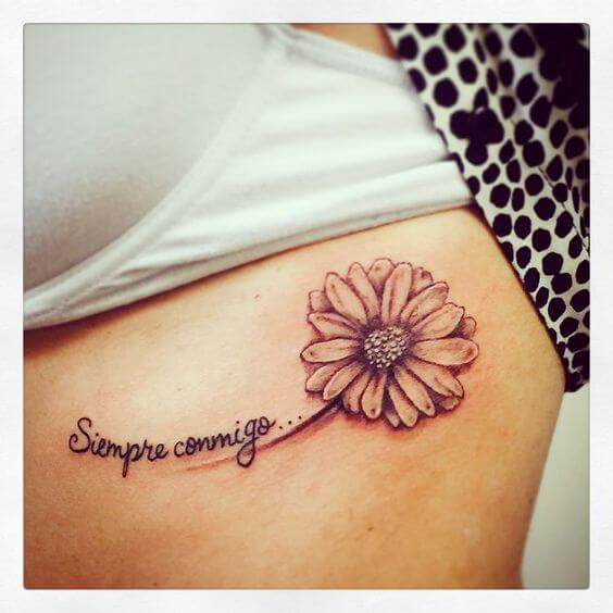 3d gerbera daisy flower with quote tattoo design idea on side ribs for women