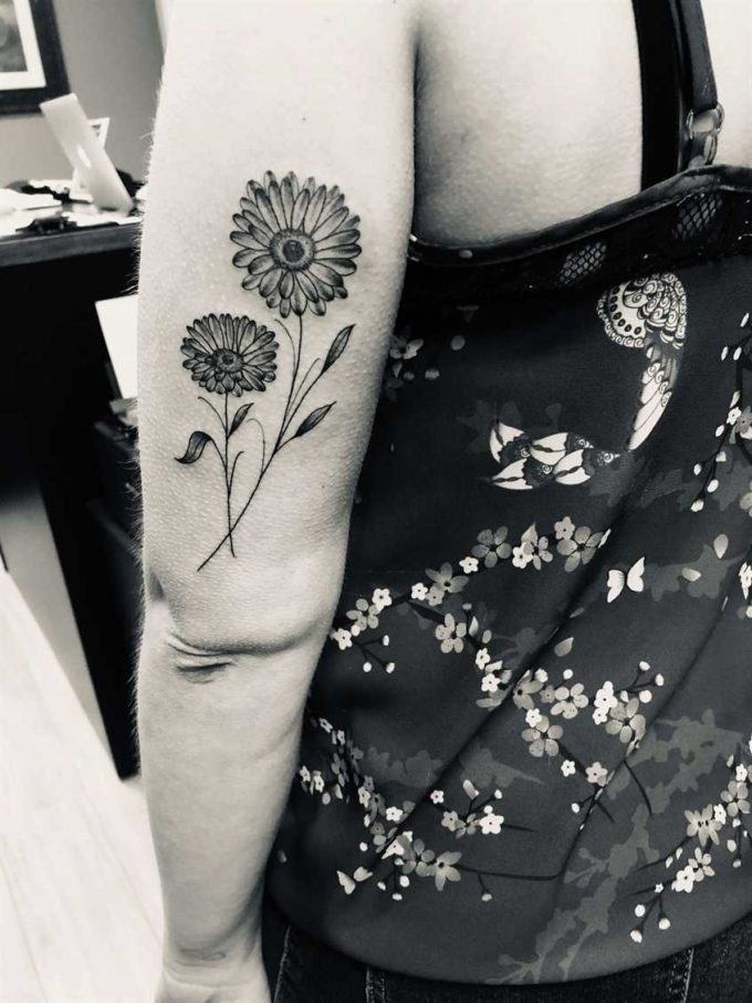 wonderful back arm black gerbera daisy flowers tattoo designs for women