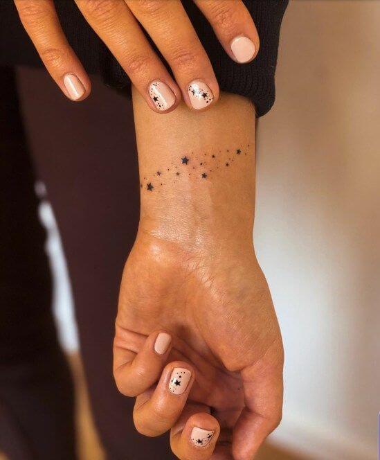 cosmic stars small meaningful tattoo design idea on wrist for women