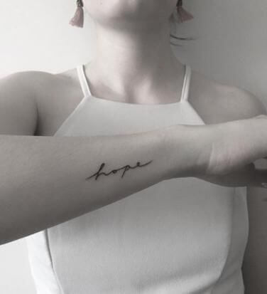hope small meaningful word tattoo idea on side wrist for women