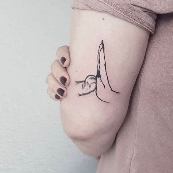 paw touching palm small meaningful tattoo design idea on arm for women