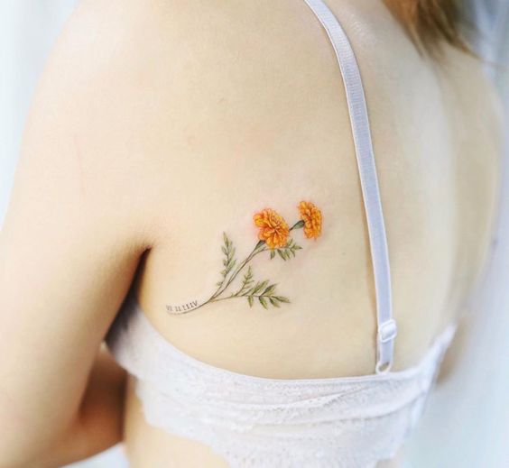 roman birth date with marigold birth flower tattoo design idea on shoulder blade for females