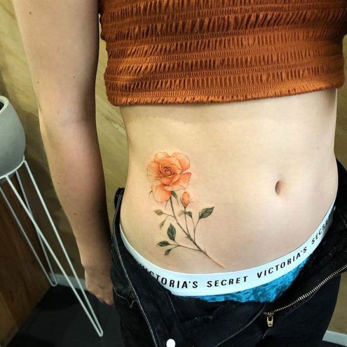 beautiful rose bud v-line tattoo design idea for females