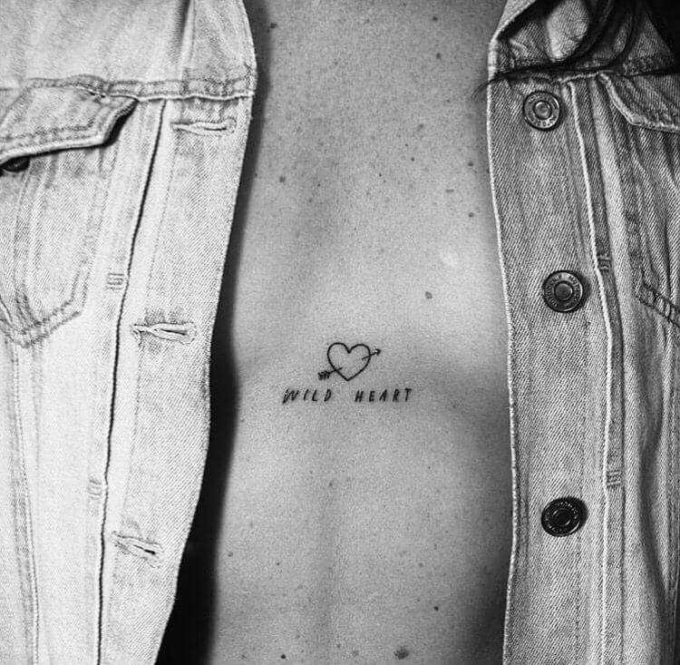 wild heart quote with arrow heart minimal love tattoo design idea on chest for females