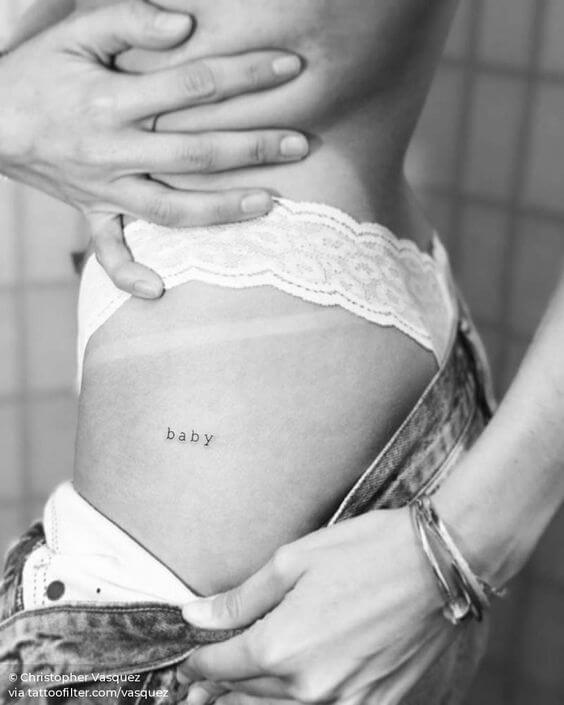 minimal text baby tattoo idea on side hip for females