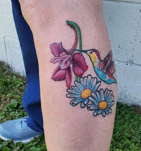 colorful hummingbird with july birth flower tattoo design idea