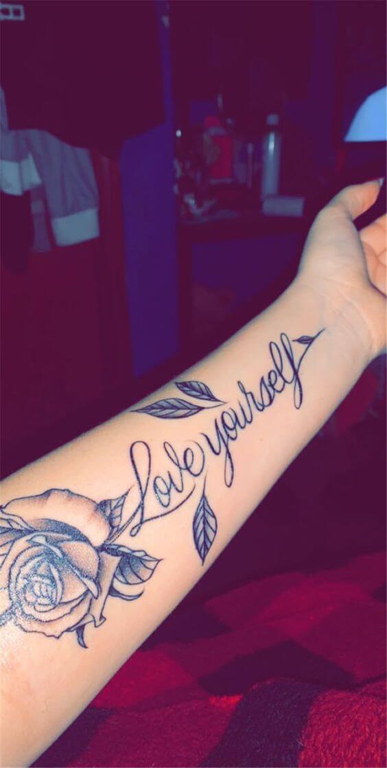 rose flower with signature love yourself forearm tattoo design for women