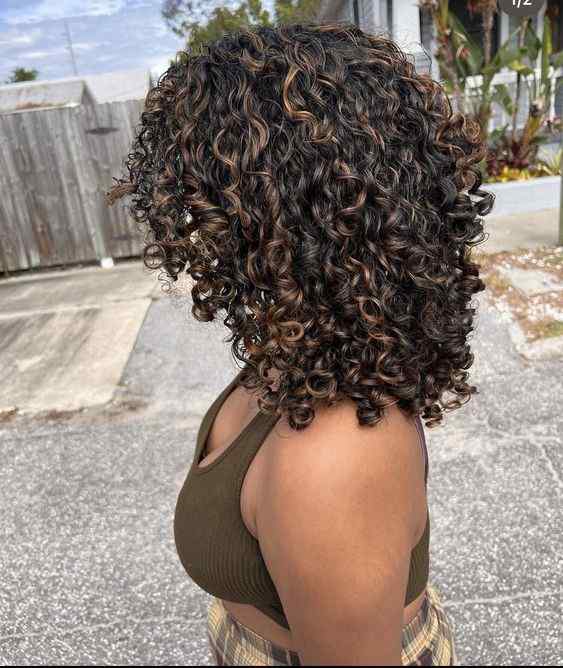 natural curly hair with caramel highlights