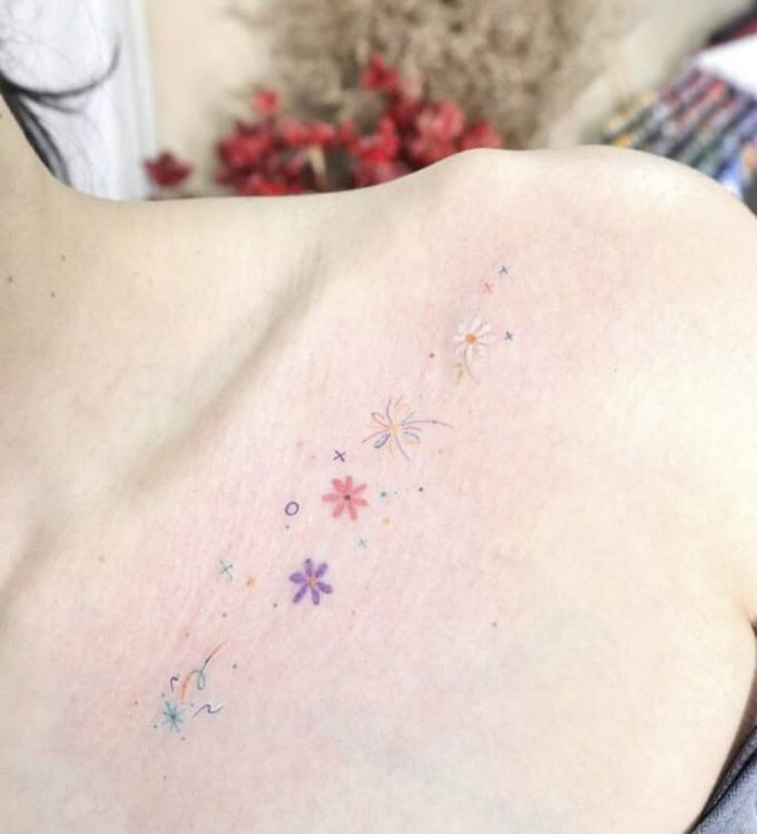 purple pink and white flowers with stars tattoo design on collar bone