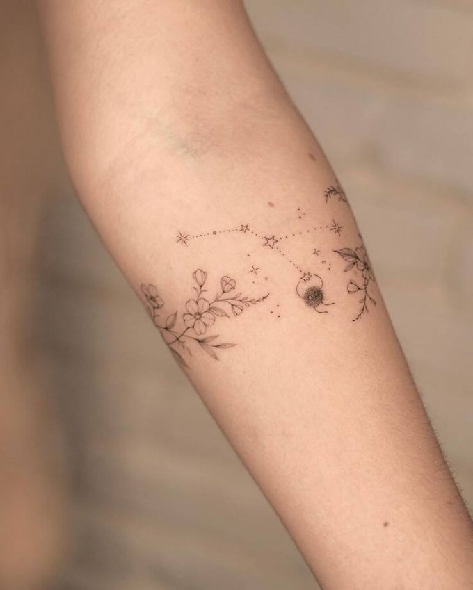 constellation stars and wildflowers tattoo design on forearm