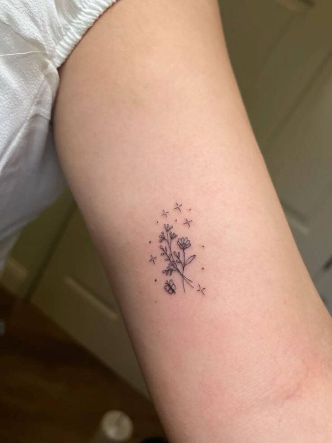 tiny flowers and stars tattoo design on inner arm